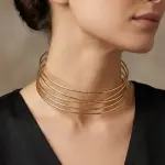 A wide gold necklace featuring multiple thin, sleek layers N-83