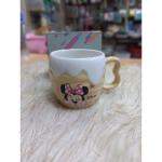 A uniquely designed porcelain mug in light beige with a raised embossed design